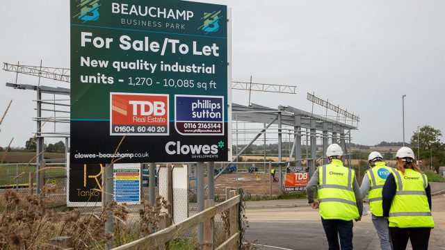Beauchamp Business Park, Unit A. Three people walking away and a large advertising board to the left