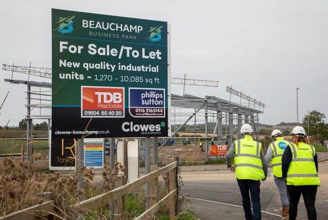 Beauchamp Business Park, Unit A. Three people walking away and a large advertising board to the left