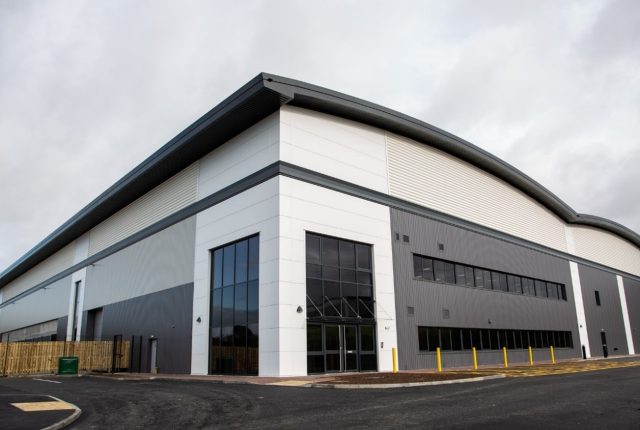 Castlewood Business Park, unit 10. Grey and white warehouse unit with grey sky