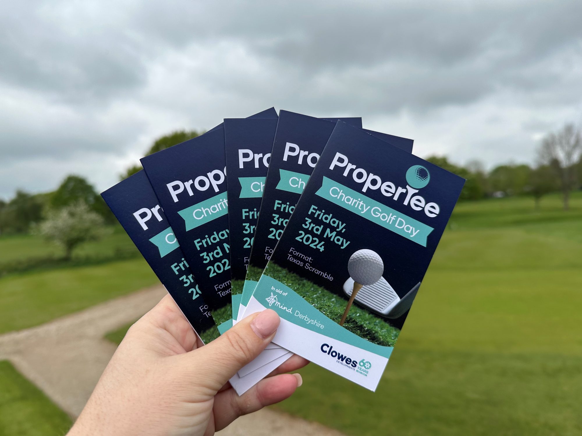 Clowes Developments ProperTee golf day Golf score cards fanned with course in background