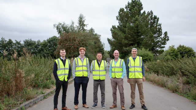 Five men in high vis jackets with trees in the background