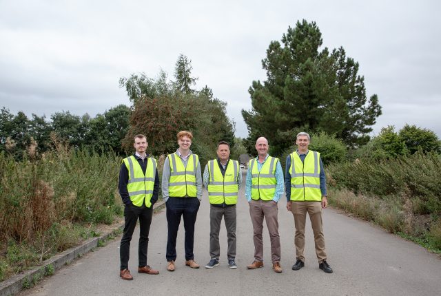 Five men in high vis jackets with trees in the background