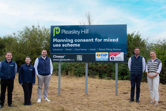 five people stood either side of a large advertising sign